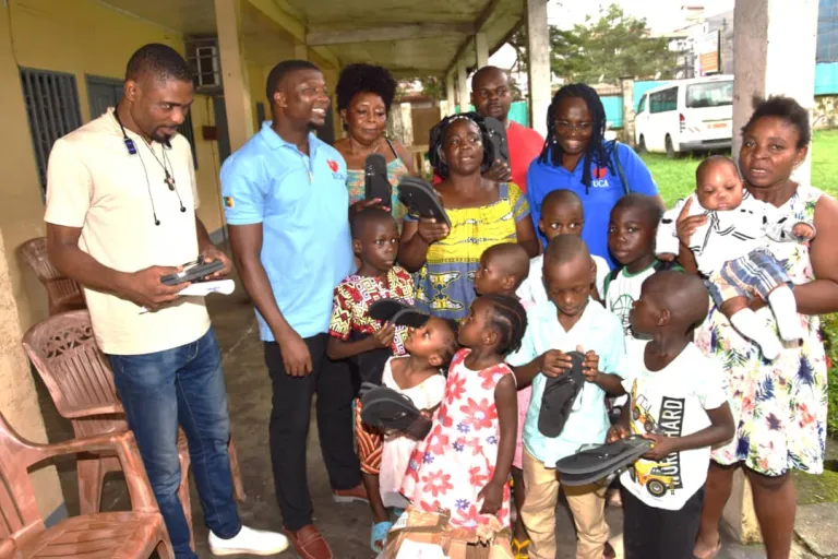 Photo de groupe lors de la distribution de tongs aux enfants